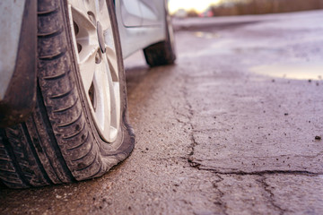 Flat tyre on road. Car tire leak because of nail pounding. Toned