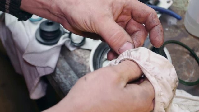 A mechanic repairs a part for a car or truck close up