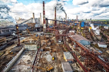 Obraz premium landscape, panorama, view of factory slums with metal hulls and machines for the production of the coking industry, smoking pipes and reconstruction of a plant in Ukraine