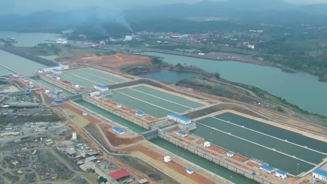 Drone flying over the new Panama canal. Massive locks control the flow and level of the water allowing ships to pass through the canal.