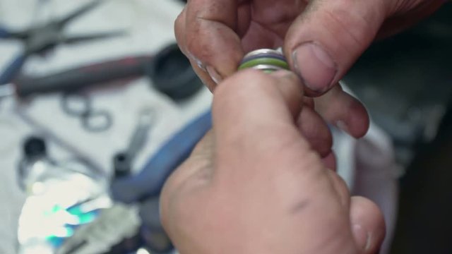A mechanic repairs small part for a car or truck closeup
