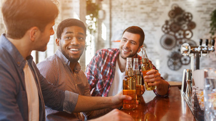 Guys drinking beer for meeting in bar
