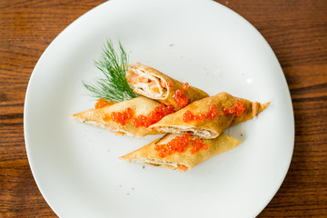 pancakes rolls with salmon and red caviar