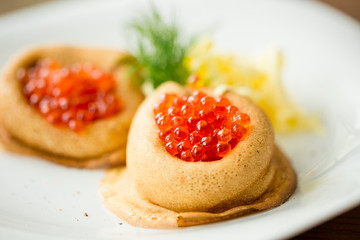 fresh pancakes with red caviar and oil
