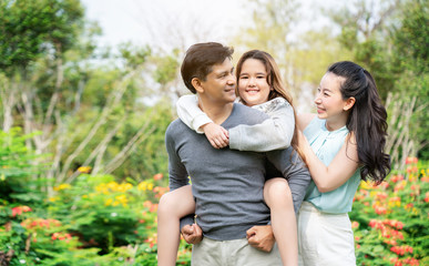 Asian family consists of parents and daughter are walking in the garden. During long holiday of...