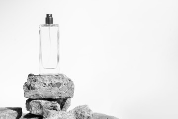 luxury perfume bottle glass packaging with stone rock concrete grunge on white background, aroma...
