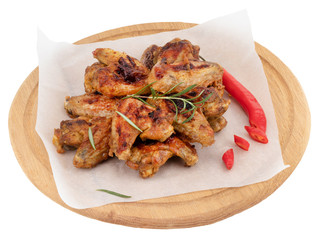 Grilled chicken wings on wooden cutting board isolated on white background