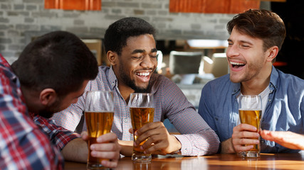 Friends meeting. Men drinking beer and talking in bar