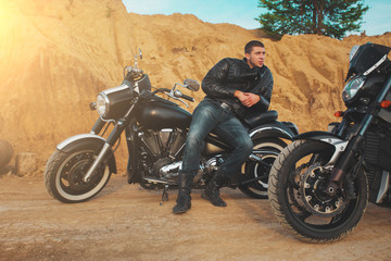 Fototapeta premium Smiling happy biker in sitting unknown on big chopper bike on road