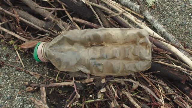 A close-up of a plastic bottle on the beach.