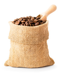 Full bag of coffee beans and wooden spoon closeup on a white background.