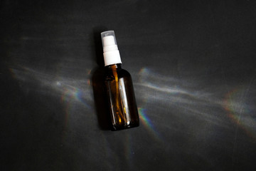 Brown glass bottle reflection on grey background. Cosmetic bottle. Eco package