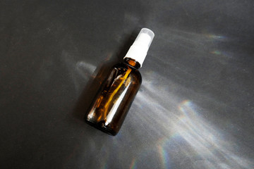 Brown glass bottle reflection on grey background. Cosmetic bottle. Eco package