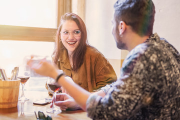 Young couple laughing on a tavern table and having fun together