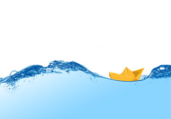 Onda del mare o di piscina con barchetta di carta gialla che galleggia serena in mezzo alla schiuma