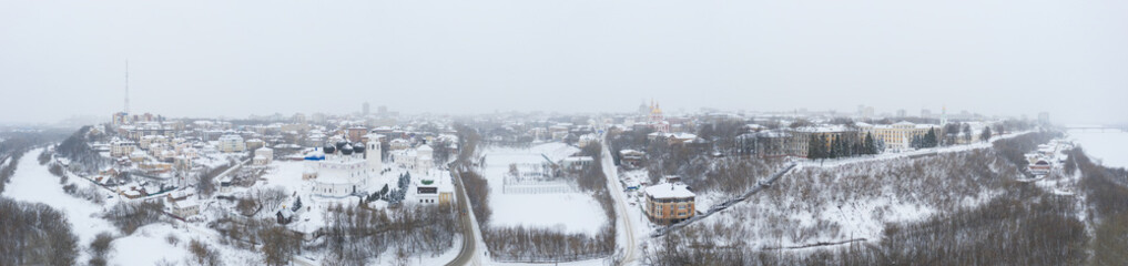 the city of Kirov and the high bank of the river Vyatka and the Alexander Grin Embankment and and Trifonov Monastery on a cloudy winter day.