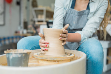 girl makes a jug of his own hands in a pottery workshop	