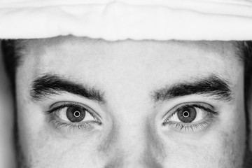 close up view of the eyes of a young man. black and white. led ring reflection in the eyes