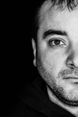 Obraz premium close up half side portrait of a young man. studio shot. led ring reflection in the eyes