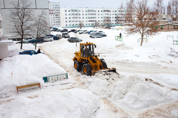 Clearing snow in Russia. Grader clears the way after a heavy snowfall. Tractor clears the road in...