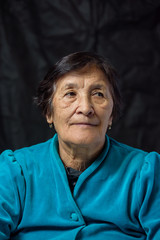portrait of an elderly thoughtful woman on a dark background