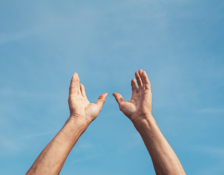 Man's hands rising to the sky