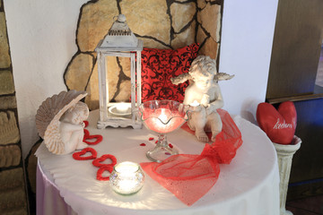 Serca czrwone, świece i posągi na stole w restauracji.