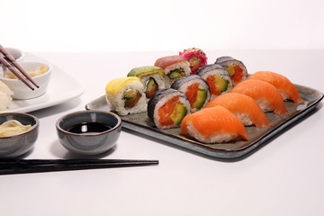 close up of sashimi sushi set with chopsticks and soy - sushi roll with salmon and sushi roll with smoked eel