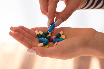 Woman take pills. Pain. Pills. Hand. Capsule. Vitamins on white background. Vitamins. Drugs. Colorfull. Life care. Medication on the lab. Tablets on hands. Painkiller. Headache. Ballyache. Handache.