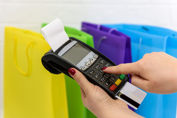 Female hand pressing buttons on terminal with card