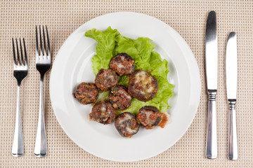 Baked champignon mushrooms stuffed with green salad on a white plate.