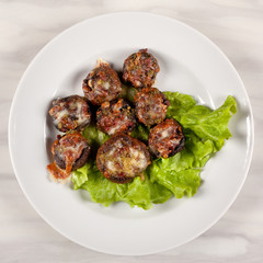 Baked champignon mushrooms stuffed with green salad on a white plate.