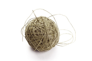 Coarse thread ball and needle on white background. Linen coarse gray threads and needle.