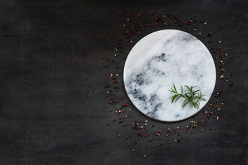 Condiments and spices on round stone board. Top view, close-up on vintage wooden background