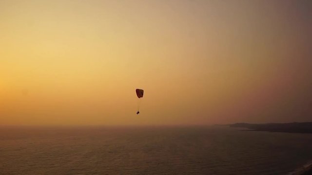 Paragliding in the sunset over the ocean, Arambol, India.