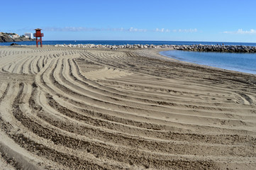 Fototapeta na wymiar Playa, surcos en la arena, limpieza de playas, Benalmádena, Málaga.