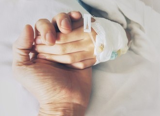 Hand in hand, Parents holding a child hand wrapped with gauze for support in the hospital.