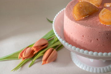 Almond cake with strawberry and grapefruit on vintage background with tulips.