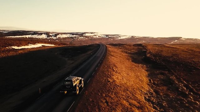 Aerial view of an Icelandic 4x4 expedition vehicle driving through beautiful landscape durring golden hour.