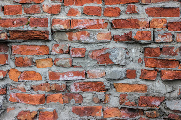 Old damaged red brick wall with cement joints, texture background, closeup.