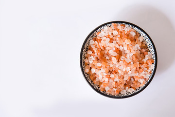 Himalayan mountain pink rock salt on a white background in a round bowl