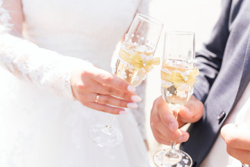 Hands newlyweds with  the glasses of champagne