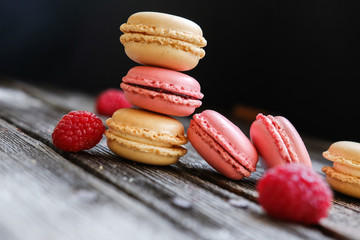 Close-up photo. Colorful French macarons with raspberries on a table