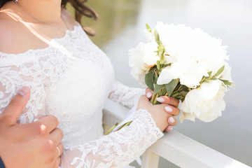White wedding bouquet in the hands of the bride