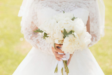 White wedding bouquet in the hands of the bride