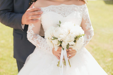 White wedding bouquet in the hands of the bride