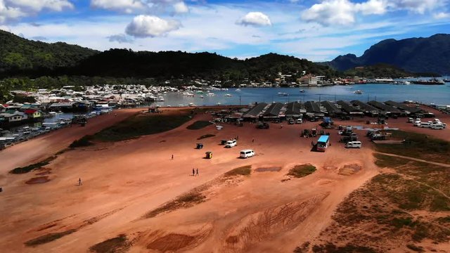 Aerial Flyover Coron Island Market on Dusty Lot.
