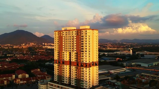An aerial shot of high rise building surrounded by low rise homes during sunset.