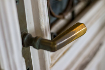 White wooden door. Yellow metal handle