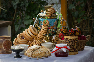 Shrovetide, pancake week.Russian style.Celebration.Tea party at the samovar with bagels, pancakes, jam in the yard.